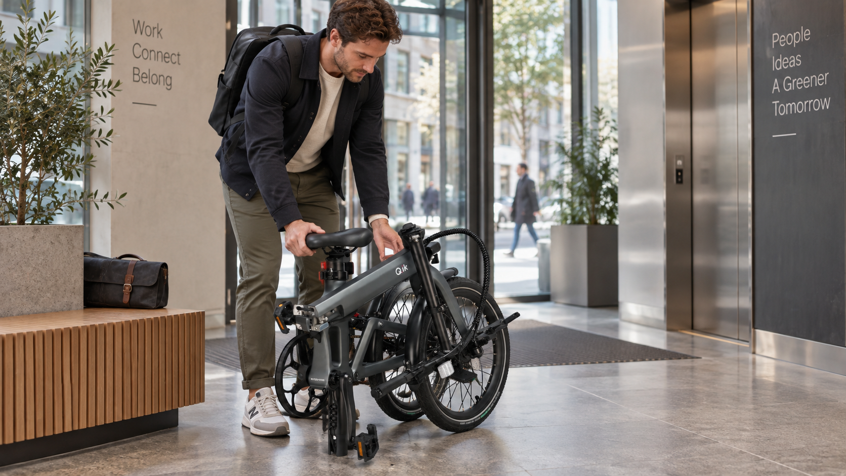 Person folding a Q.ik electric bicycle in an urban workspace
