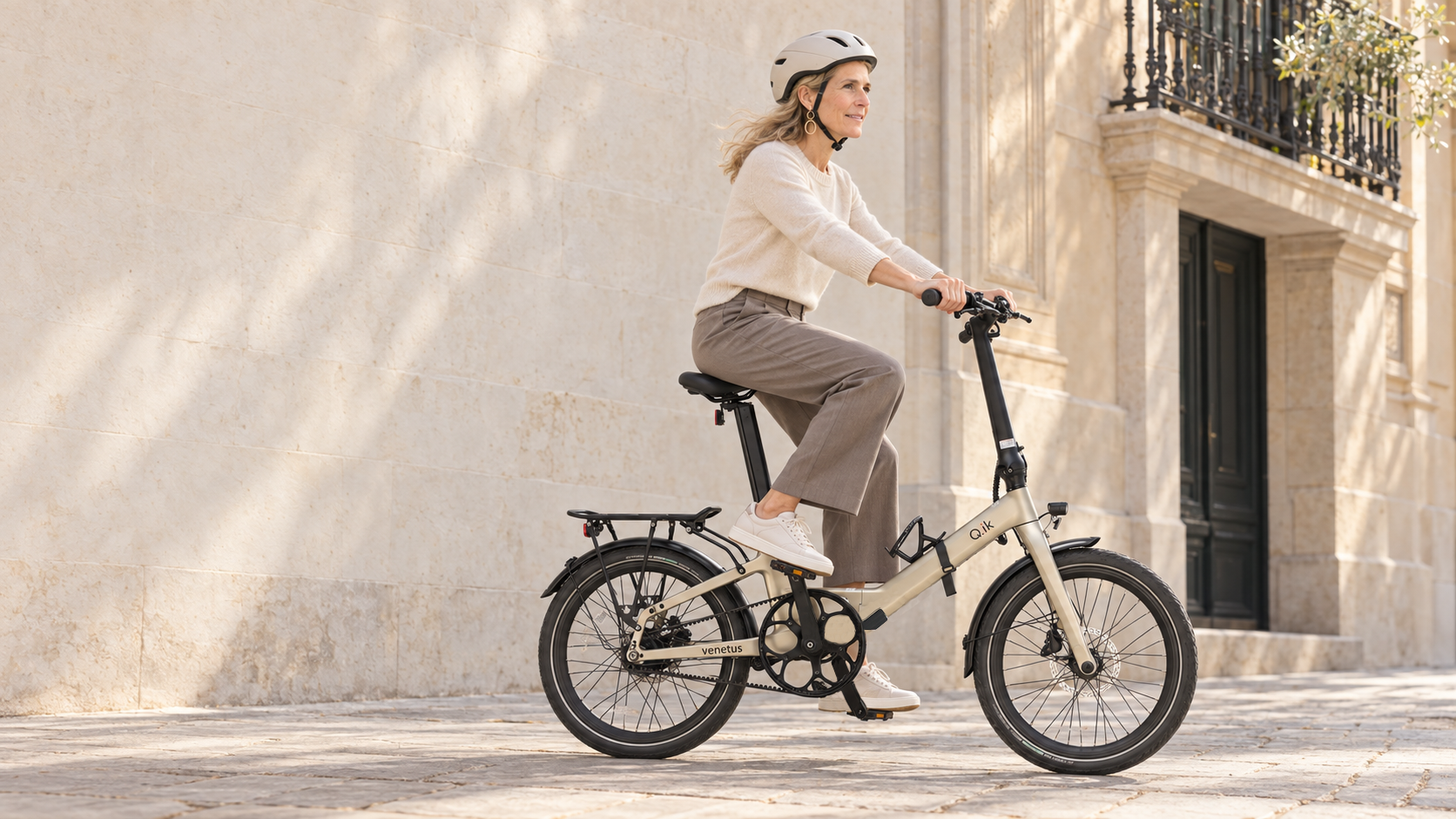 Rider on a Q.ik folding e-bike in a warm European city setting